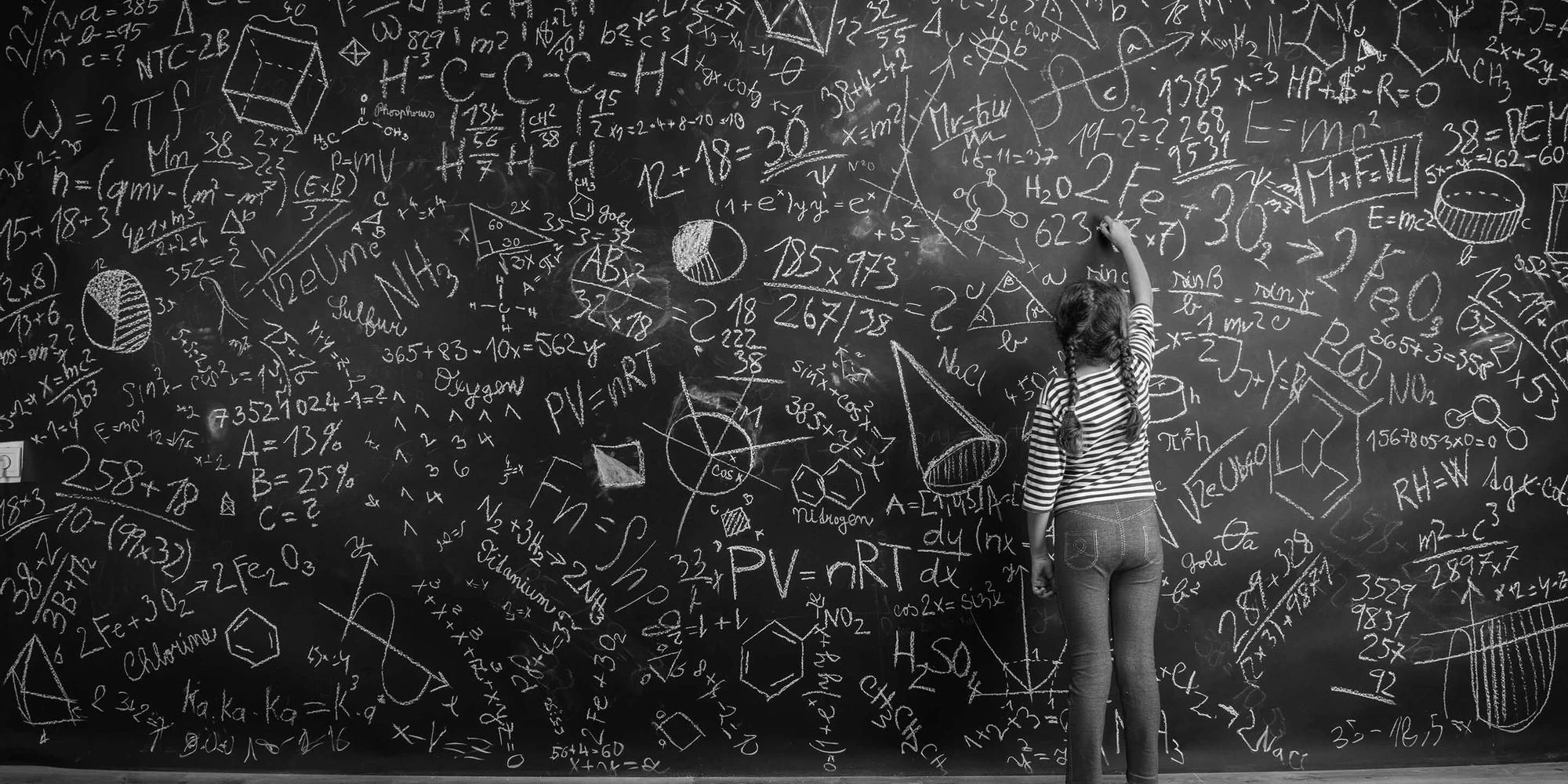 A girl is writing on a chalkboard full of math equations.